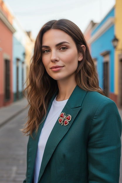 Luna Cotton butterfly lapel pin with red stones and crystals worn on a green blazer by a woman in a colourful street