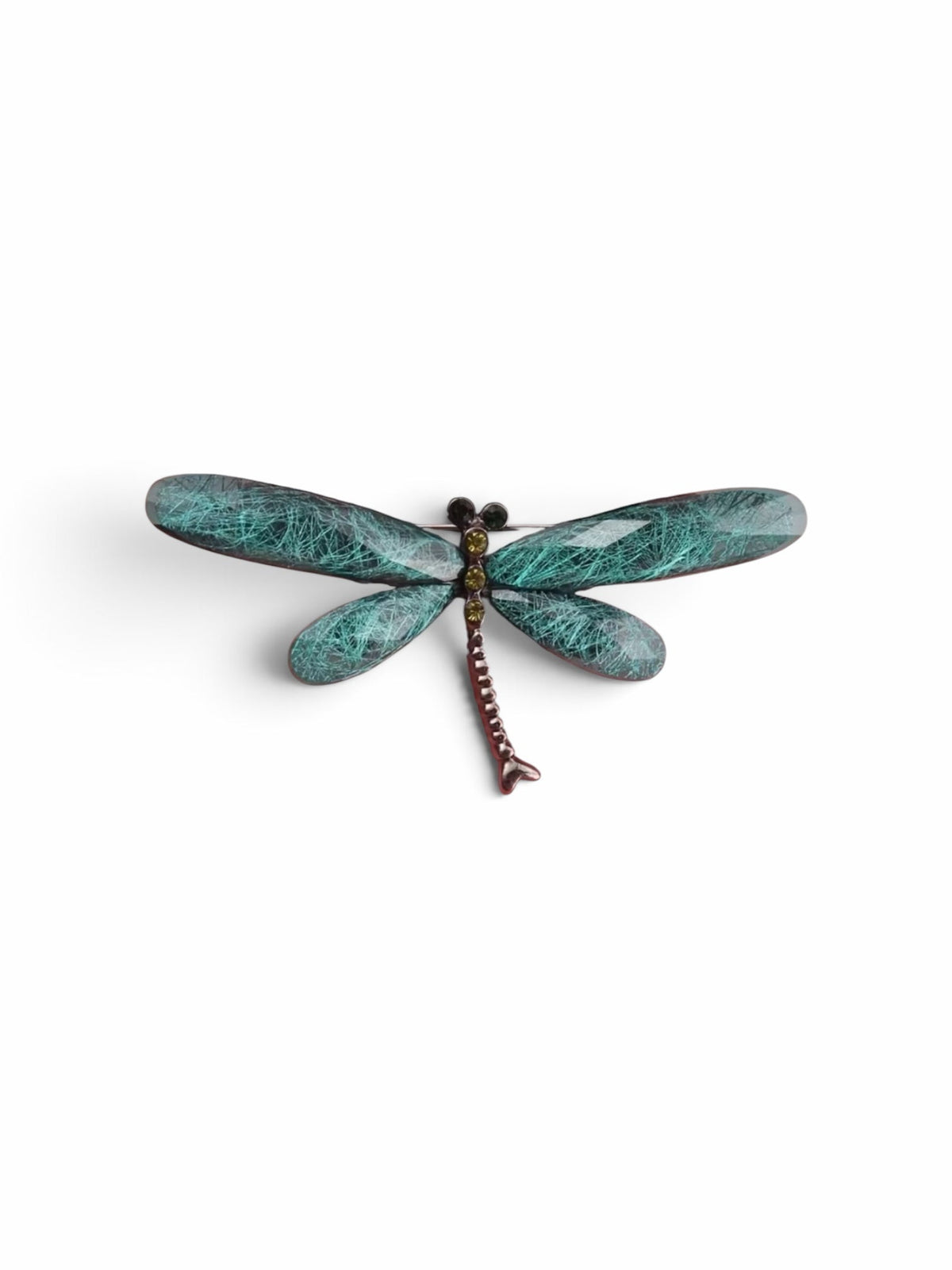 Luna Cotton dragonfly brooch with teal textured wings and a metallic body featuring small sparkling crystal accents.