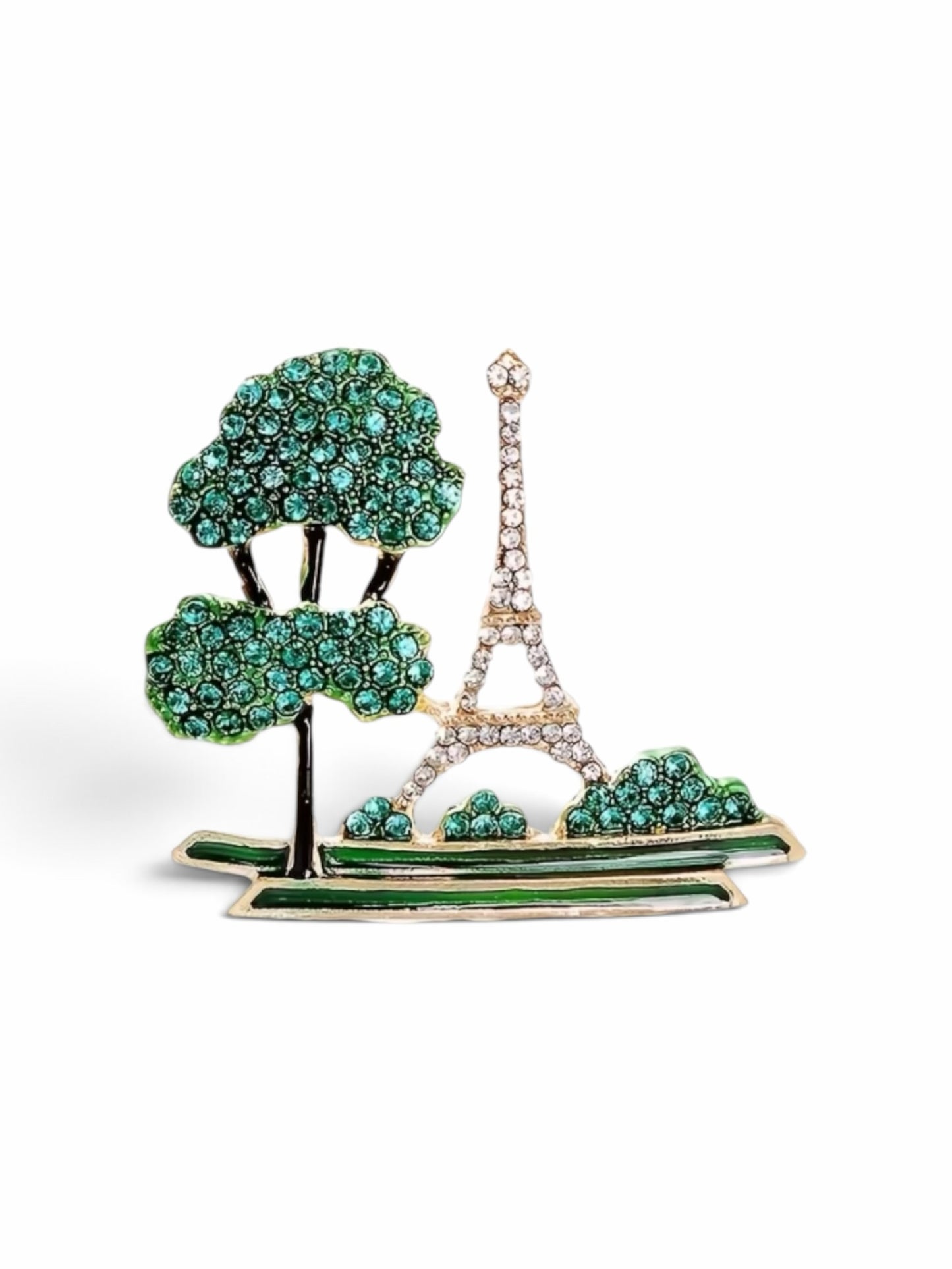 Luna Cotton gold-tone Eiffel Tower lapel brooch with clear crystals and green stone trees on a white background