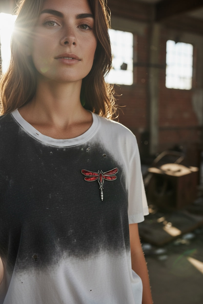 Luna Cotton dragonfly brooch with deep red enamel and silver-tone metal pinned to a woman wearing a grey t-shirt